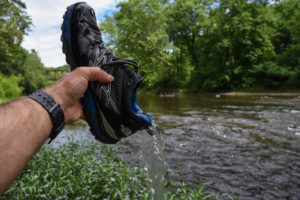 man showing waterproof strength of gore-tex hiking boots