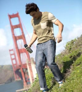 man wearing betabrand travel pants and carrying a water bottle in front of san francisco bay