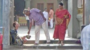 Russian backpacker begging in front of a temple in India