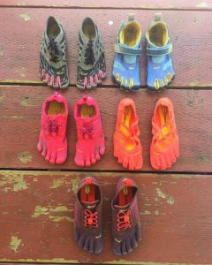5 pairs of Vibram Five finger shoes on floor