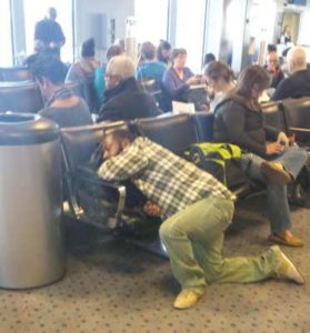 man sleeping with his head on chair during layover flight