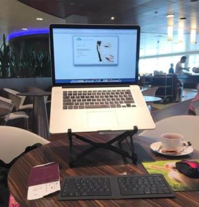 Bluetooth travel keyboard connected with Macbook on a Roost stand in a coffee shop