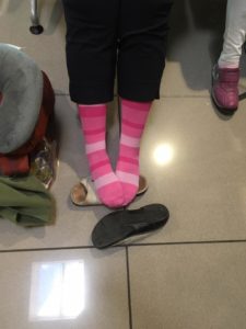 closeup of girl wearing compression socks in a waiting room