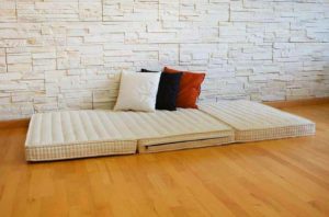 foldable mattress with pillows in living room