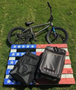 suitcase lying on american flag beside a mountain bike