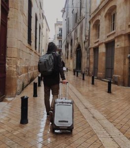 man carrying a suitcase on urban street