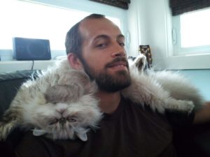 man with a cat on his neck as a pillow