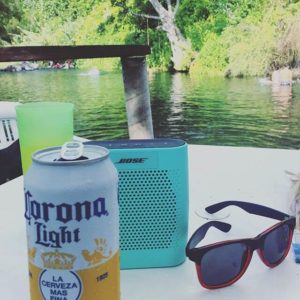 Bose portable bluetooth speaker on a table near lake