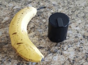A portable speaker and a banana for comparison