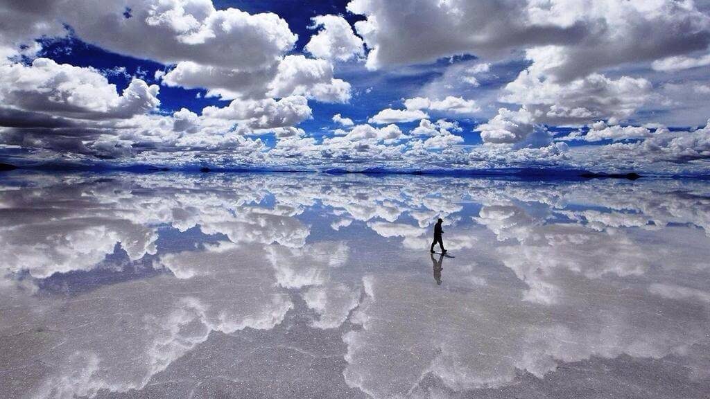 man walking on cloudy Salar De Uyuni (Salt Flats)