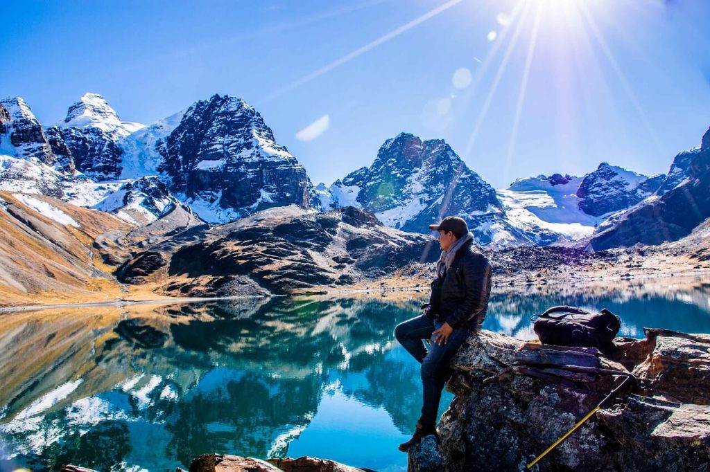 man sitting on a rock near a lake in Torotoro National Park, bolivia